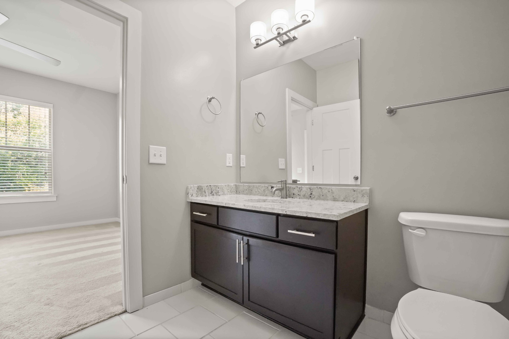 414 Rosedale Avenue, Unit 308 Nashville, TN 37211 - Photo 24 of 26 a bathroom with a granite countertop toilet a sink and a mirror