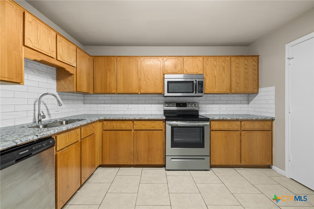 1803 Aztec Trace Harker Heights, TX 76548 - Photo 12 of 42 a kitchen with stainless steel appliances granite countertop a sink stove and cabinets