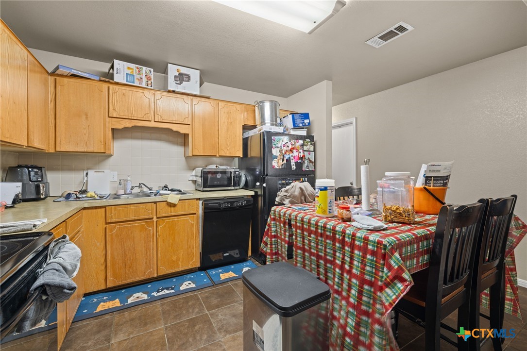 1803 Aztec Trace Harker Heights, TX 76548 - Photo 34 of 42 a kitchen with stainless steel appliances granite countertop a stove top oven a sink dishwasher and cabinets with wooden floor