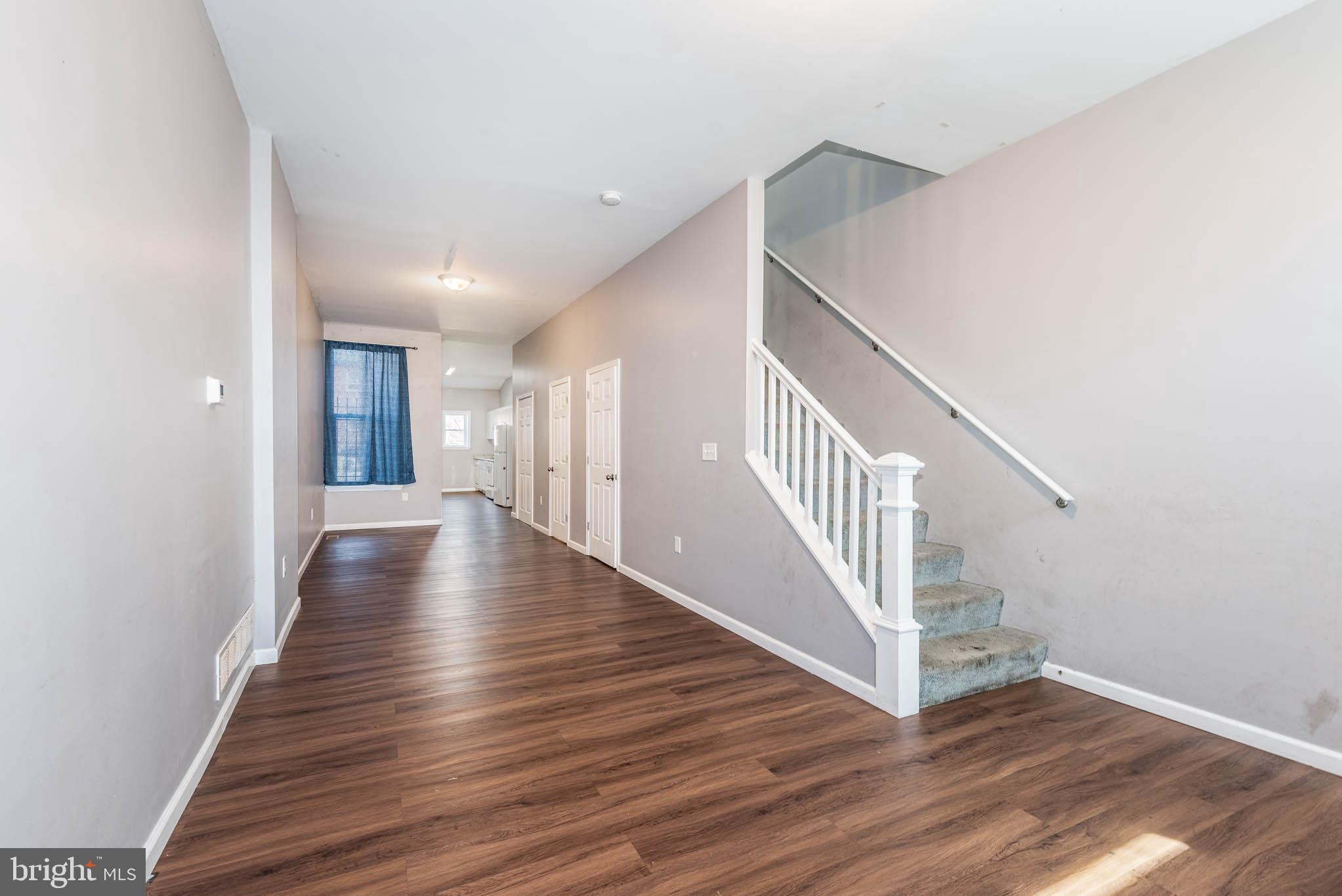 2118 East Hoffman Street Baltimore, MD 21213 - Photo 3 of 19 a view of a hallway view with wooden floor and staircase