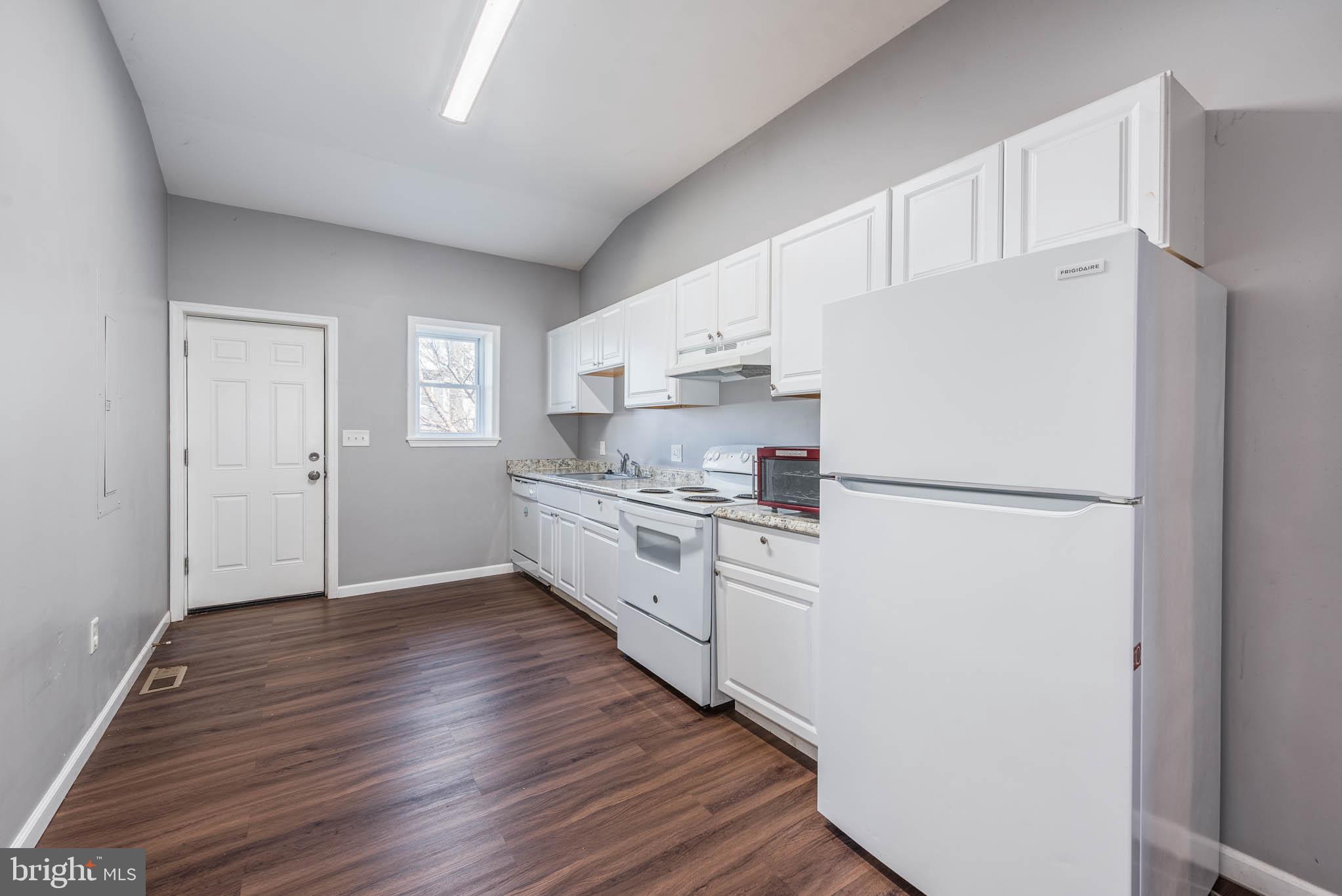 2118 East Hoffman Street Baltimore, MD 21213 - Photo 5 of 19 a kitchen with white cabinets and white appliances