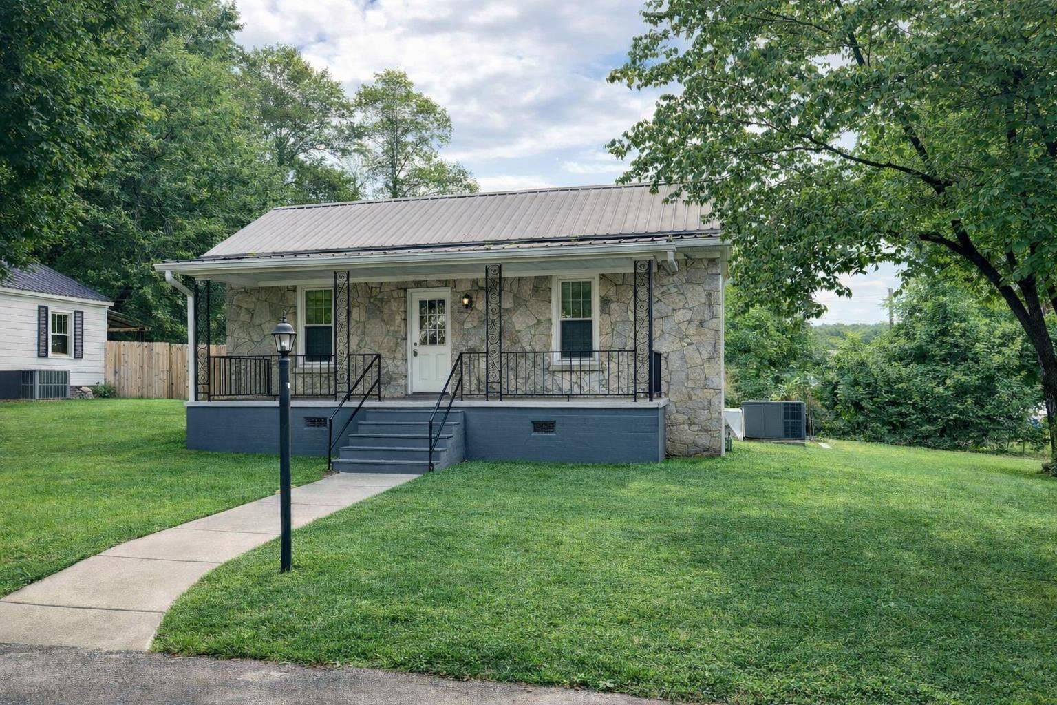 202 Morris Street Waynesboro, TN 38485 - Photo 1 of 36 Bungalow-style home with covered porch, stone siding, a front lawn, and a metal roof