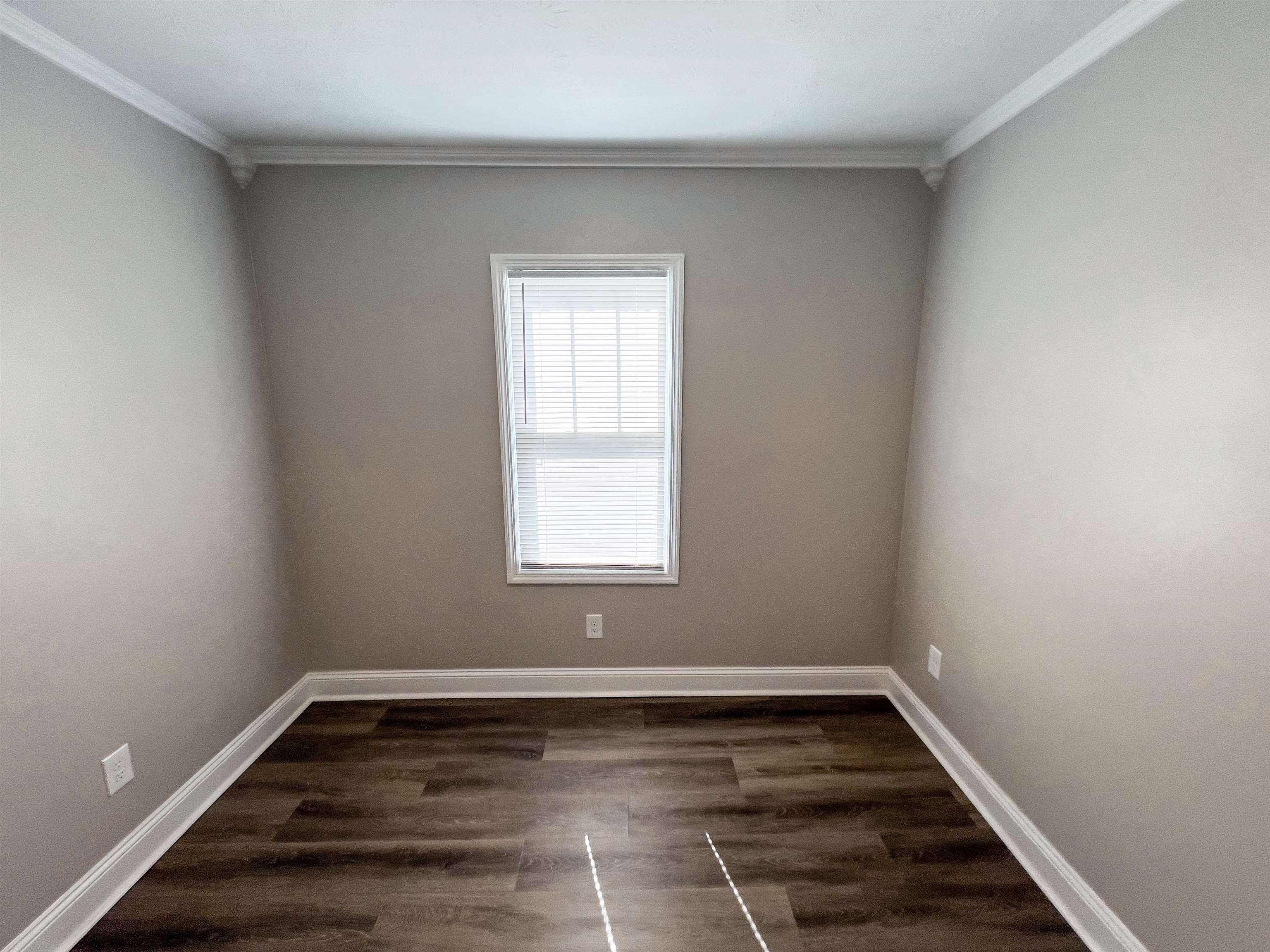202 Morris Street Waynesboro, TN 38485 - Photo 11 of 36 Empty room featuring dark wood-type flooring and crown molding