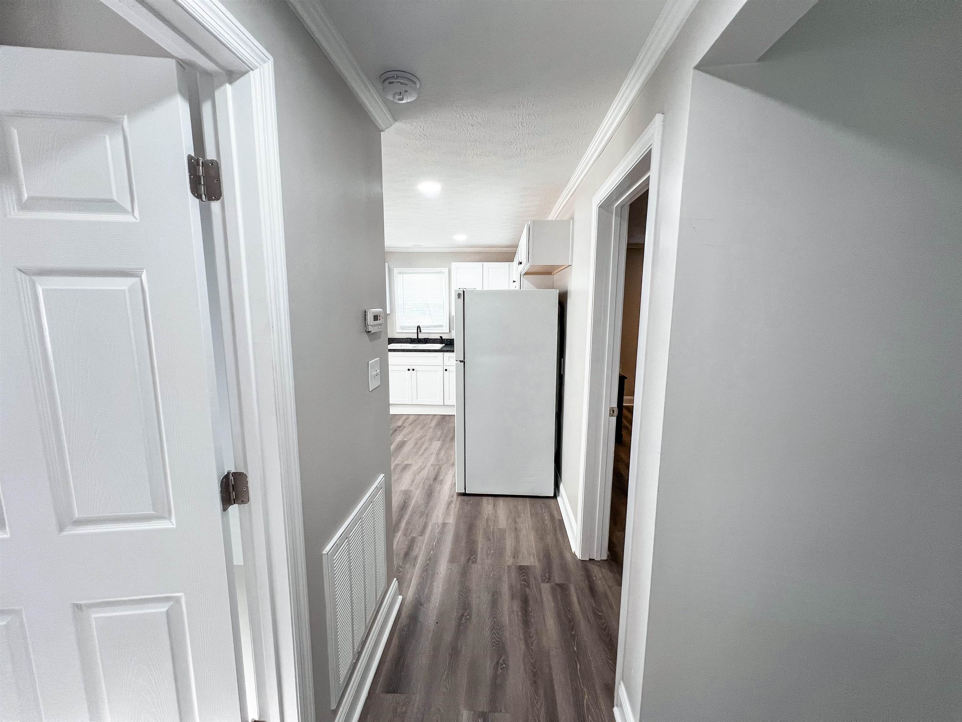 202 Morris Street Waynesboro, TN 38485 - Photo 16 of 36 Hallway featuring ornamental molding, dark wood finished floors, and a textured ceiling