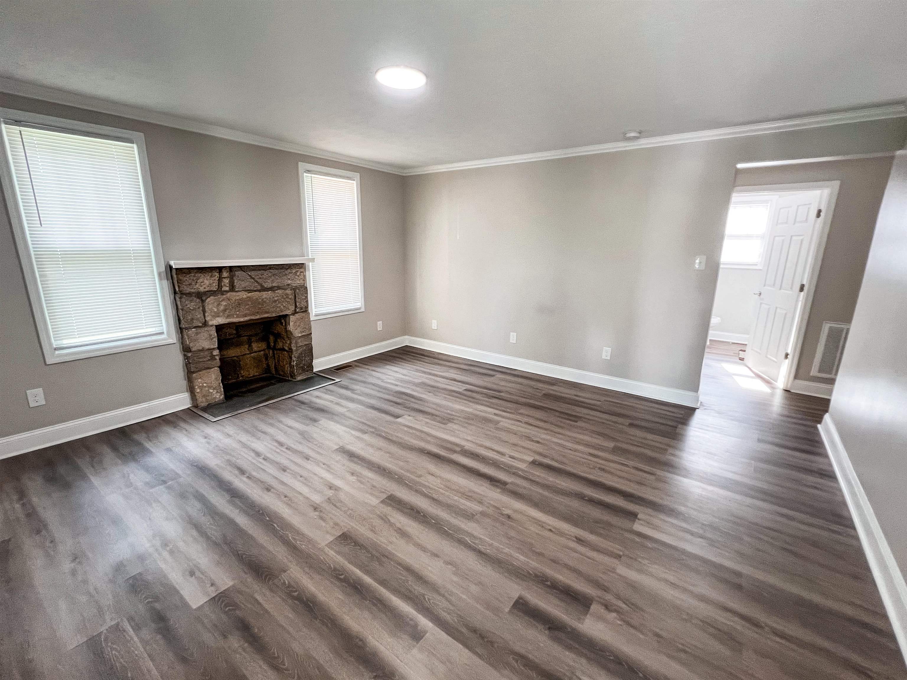 202 Morris Street Waynesboro, TN 38485 - Photo 2 of 36 Unfurnished living room with crown molding, a fireplace, and dark wood finished floors