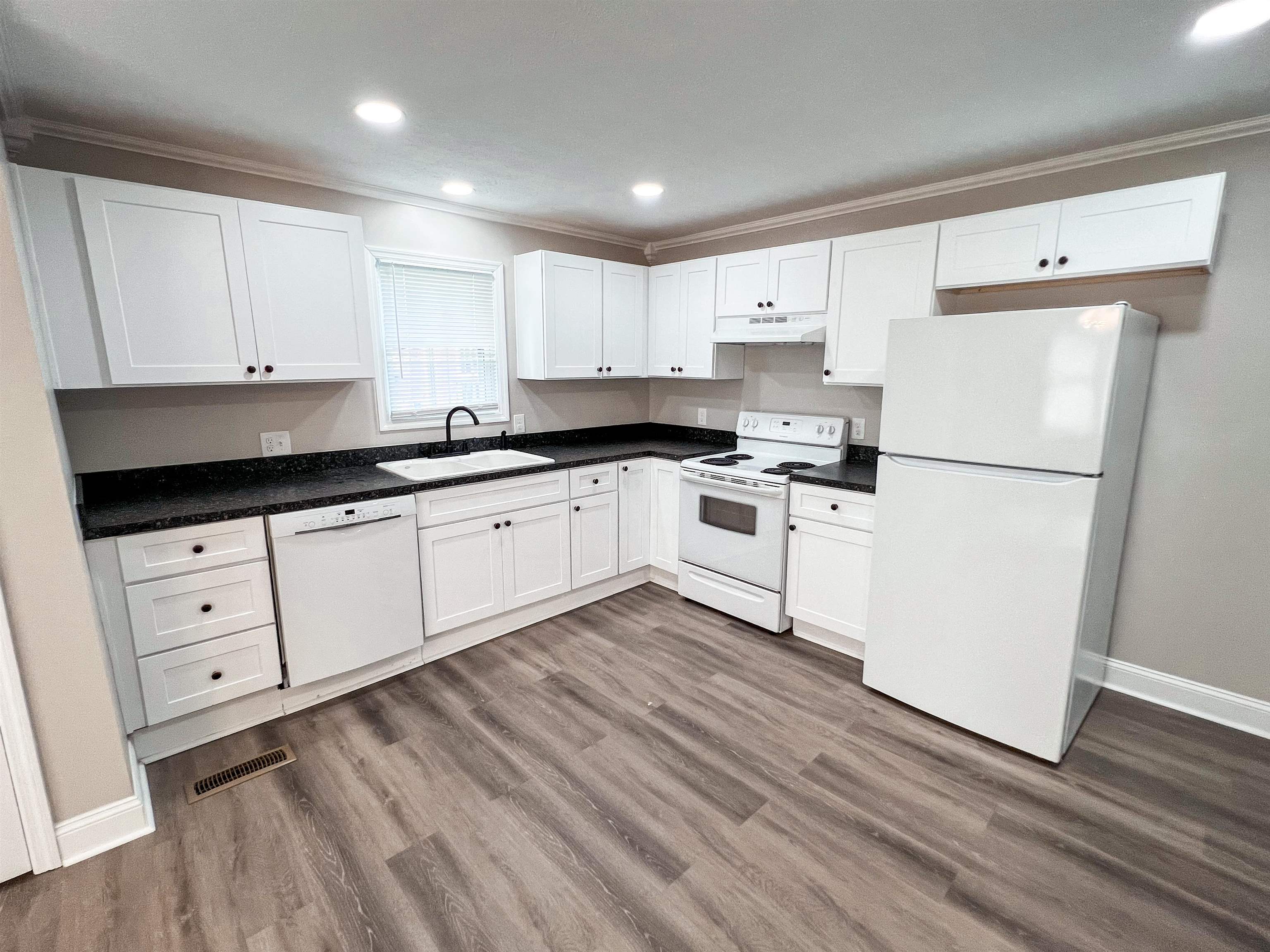 202 Morris Street Waynesboro, TN 38485 - Photo 21 of 36 Kitchen with white appliances, white cabinetry, wood finished floors, recessed lighting, and under cabinet range hood
