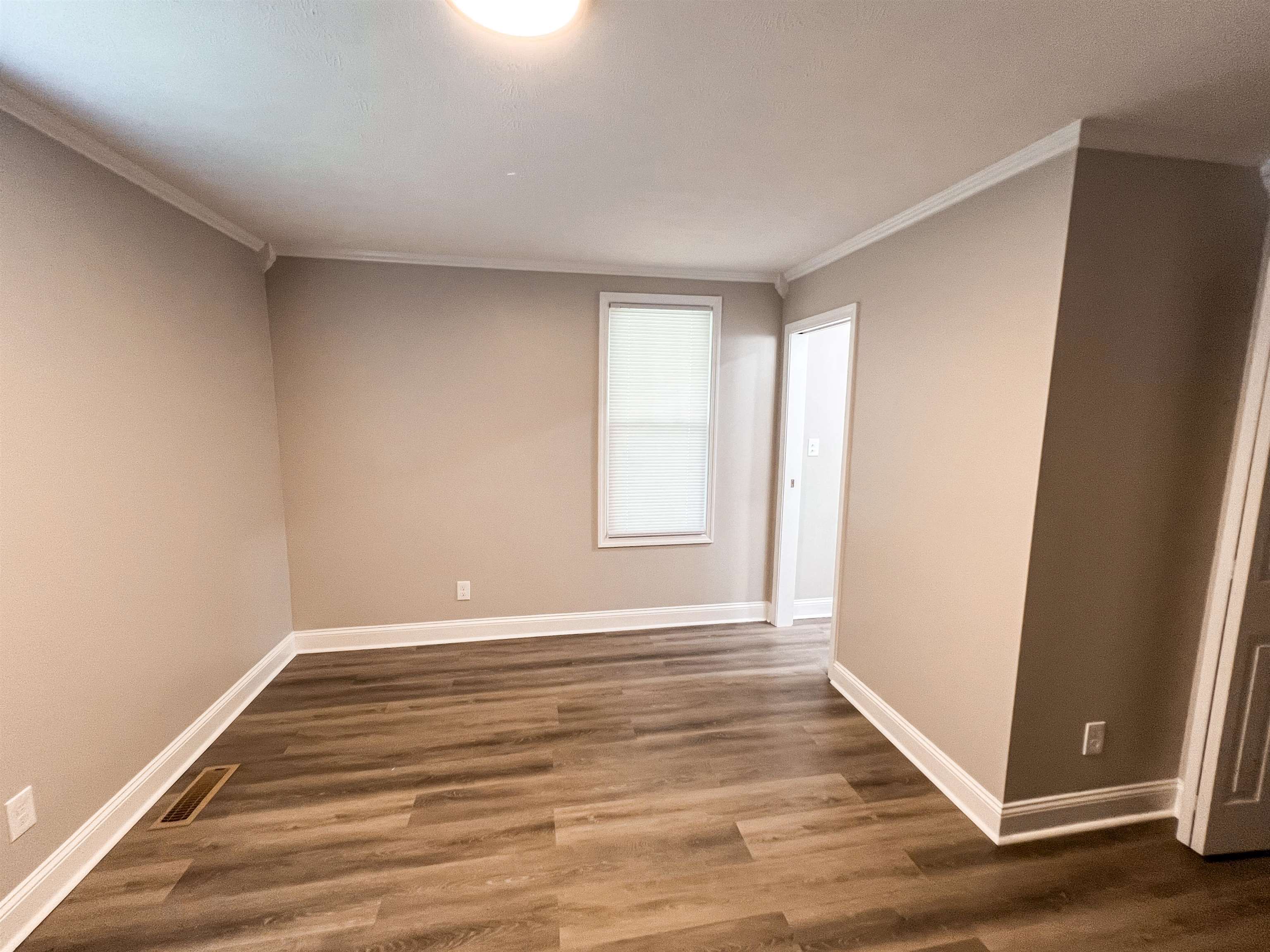 202 Morris Street Waynesboro, TN 38485 - Photo 26 of 36 Unfurnished room with crown molding and dark wood-style flooring