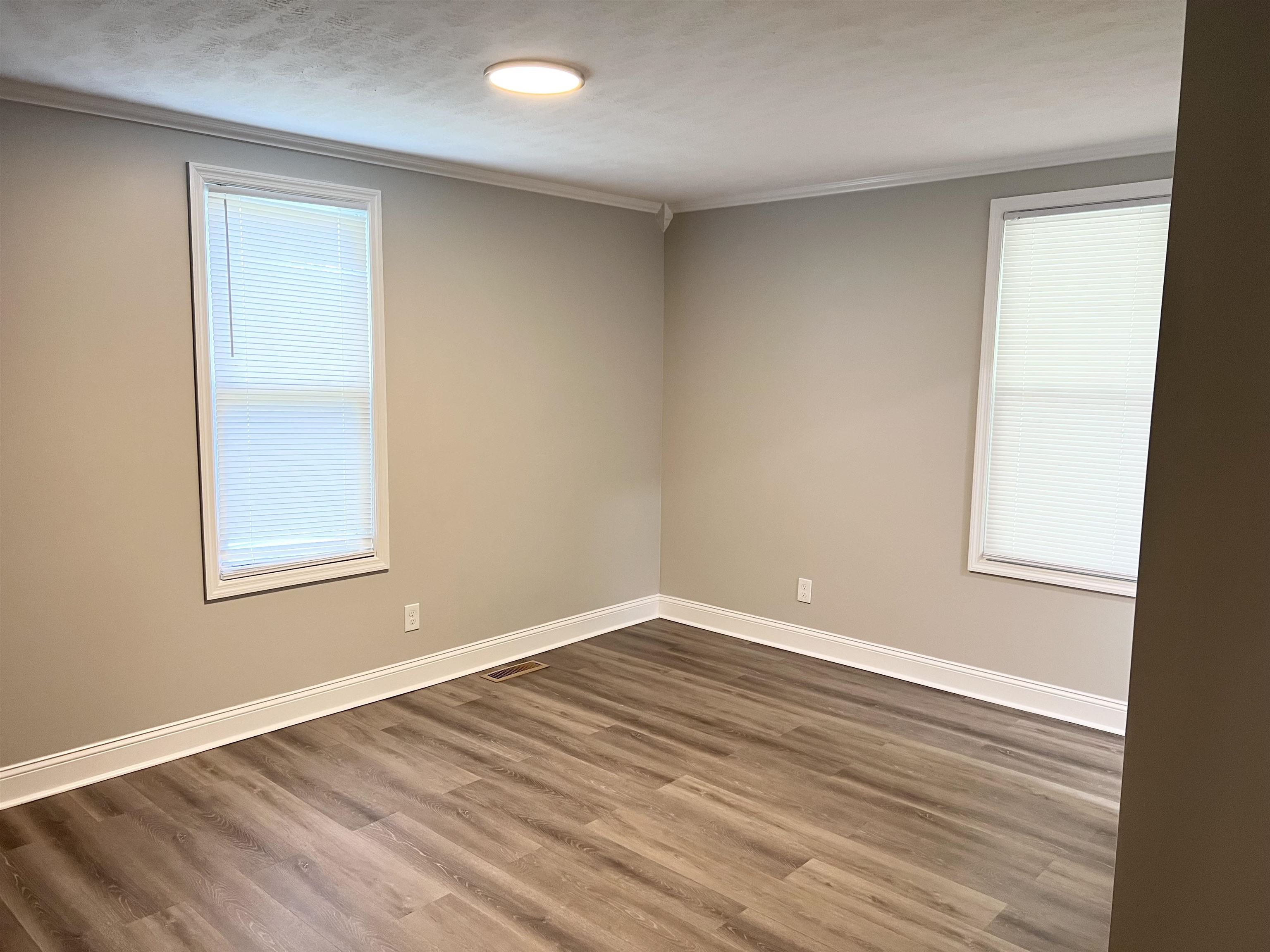 202 Morris Street Waynesboro, TN 38485 - Photo 27 of 36 Unfurnished room with dark wood finished floors, crown molding, plenty of natural light, and a textured ceiling