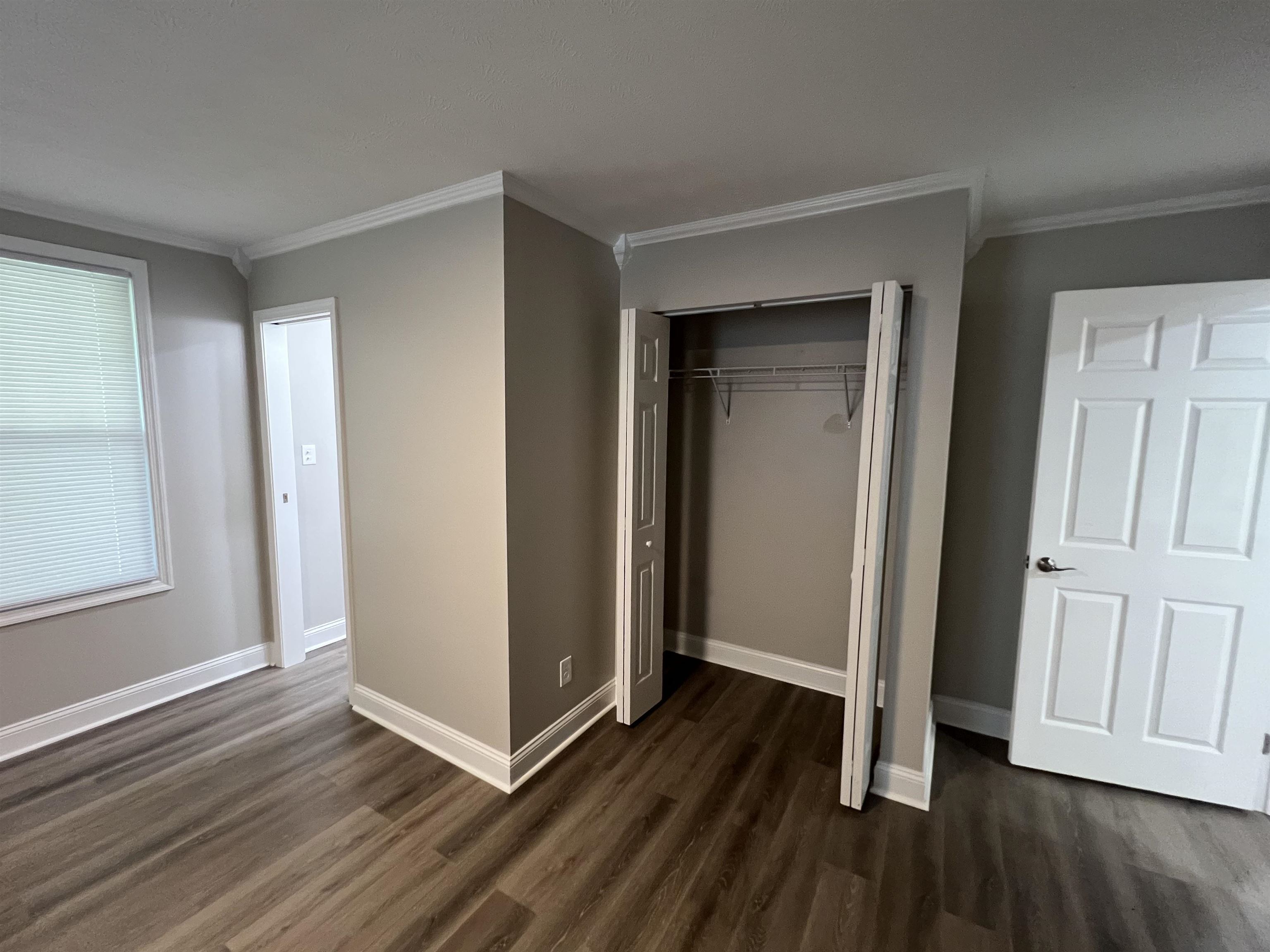 202 Morris Street Waynesboro, TN 38485 - Photo 29 of 36 Unfurnished bedroom with crown molding, dark wood-style floors, and a closet