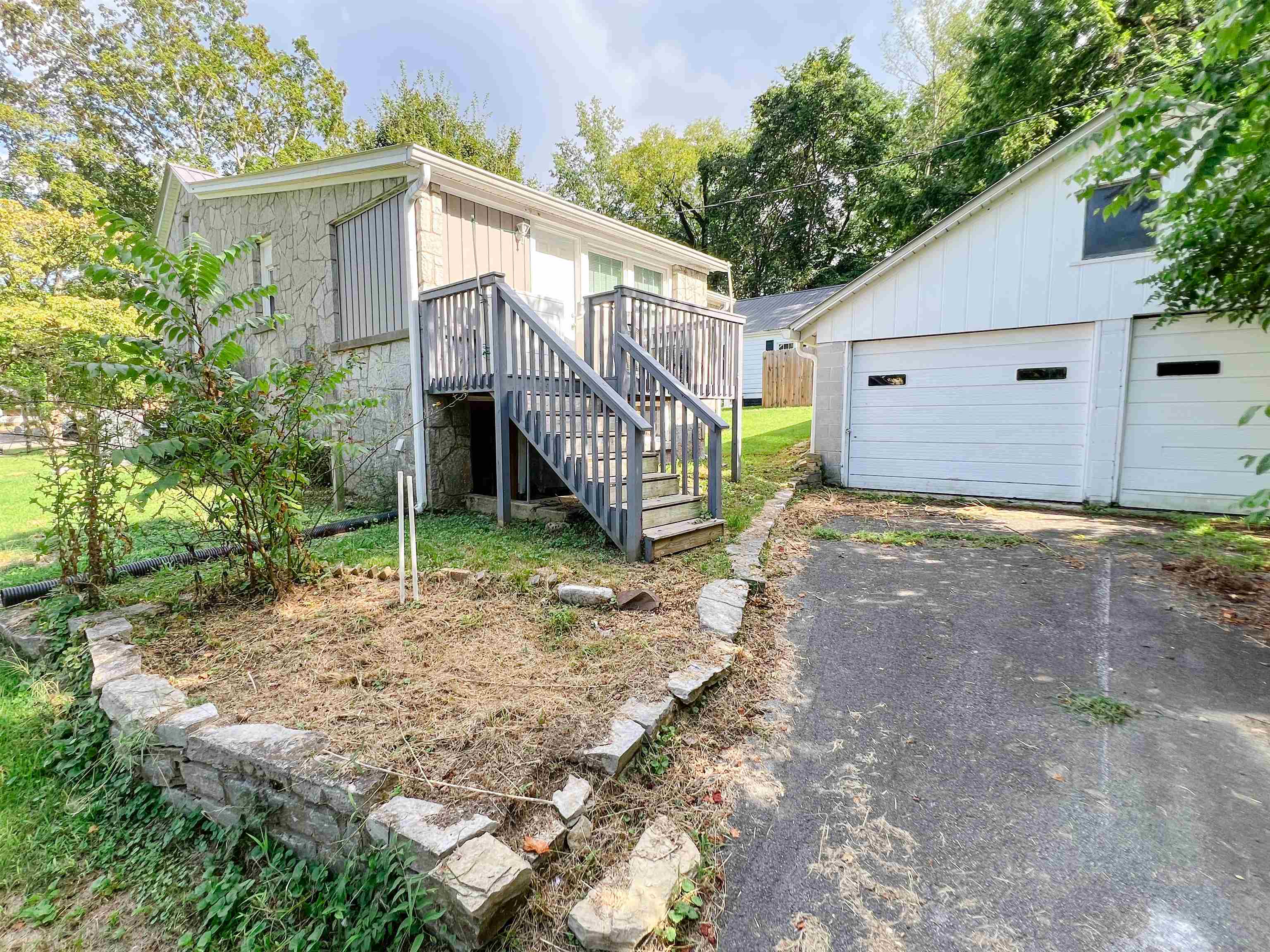 202 Morris Street Waynesboro, TN 38485 - Photo 33 of 36 Rear view of property featuring stairs, an outdoor structure, a garage, a wooden deck, and view of wooded area