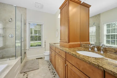 a bathroom with a granite countertop sink and a mirror a bathtub