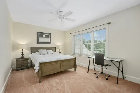 a bedroom with a bed chair and a window