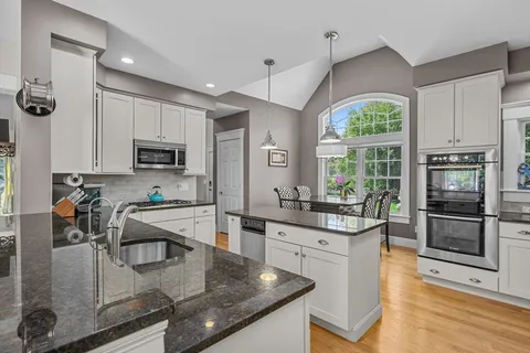 a kitchen with stainless steel appliances granite countertop a sink stove and refrigerator