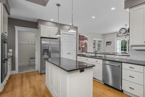 a kitchen with stainless steel appliances granite countertop a sink and refrigerator