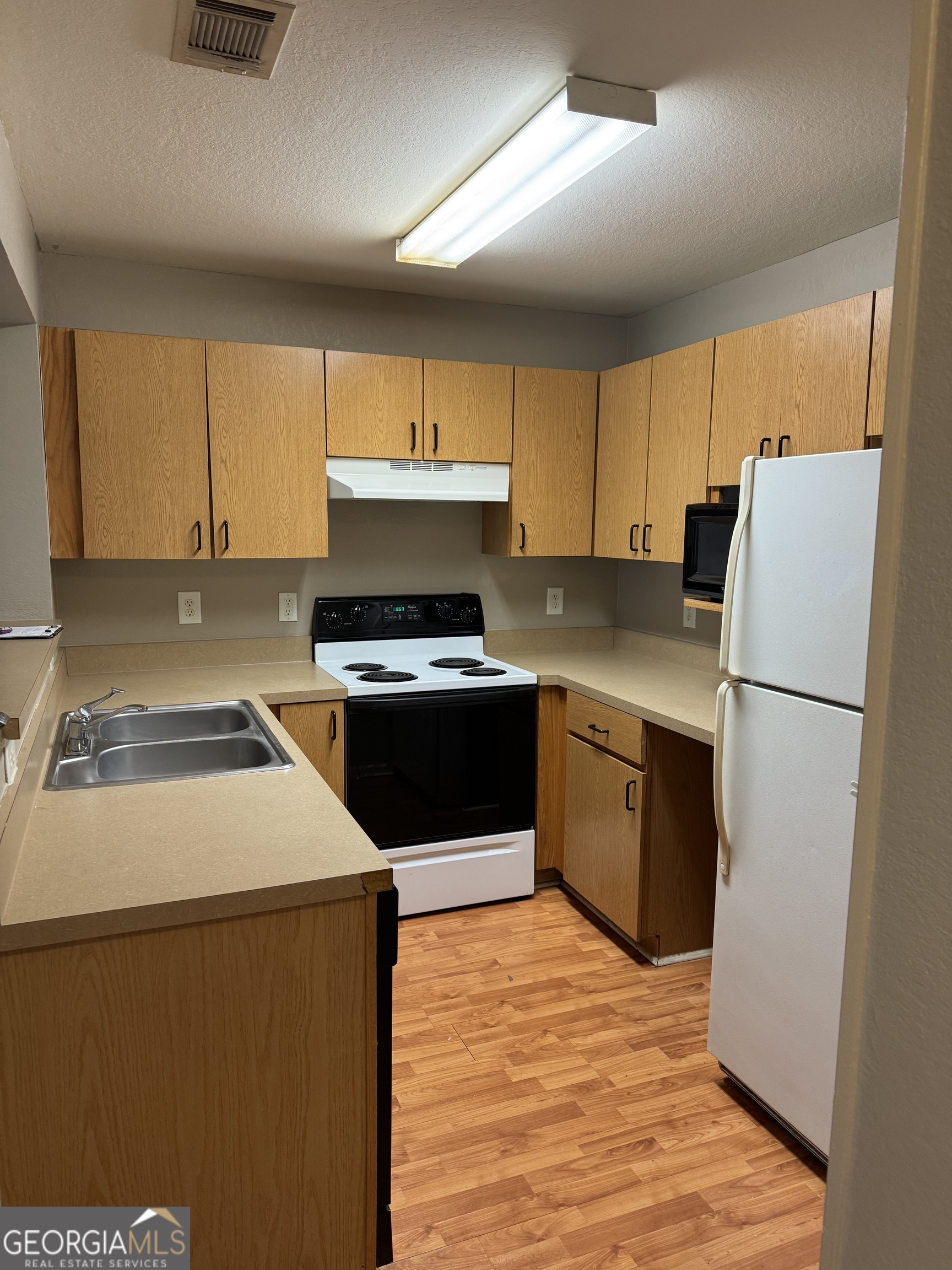 211 North Avenue, Unit 1332 Athens, GA 30601 - Photo 5 of 14 a kitchen with a refrigerator sink and cabinets