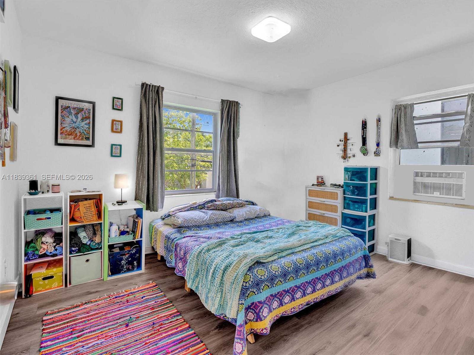 3210 Elizabeth Street Miami, FL 33133 - Photo 12 of 69 a bedroom with a bed and a bookshelf with wooden floor