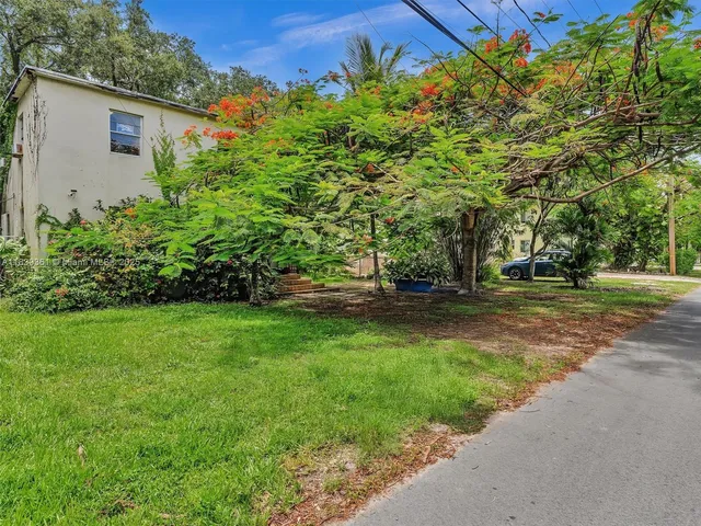 an aerial view of a house with a yard and lake view