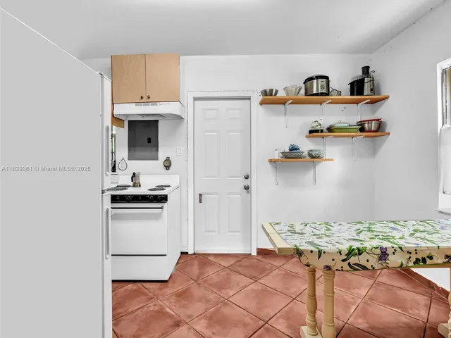 a living room with furniture a bookshelf and a window