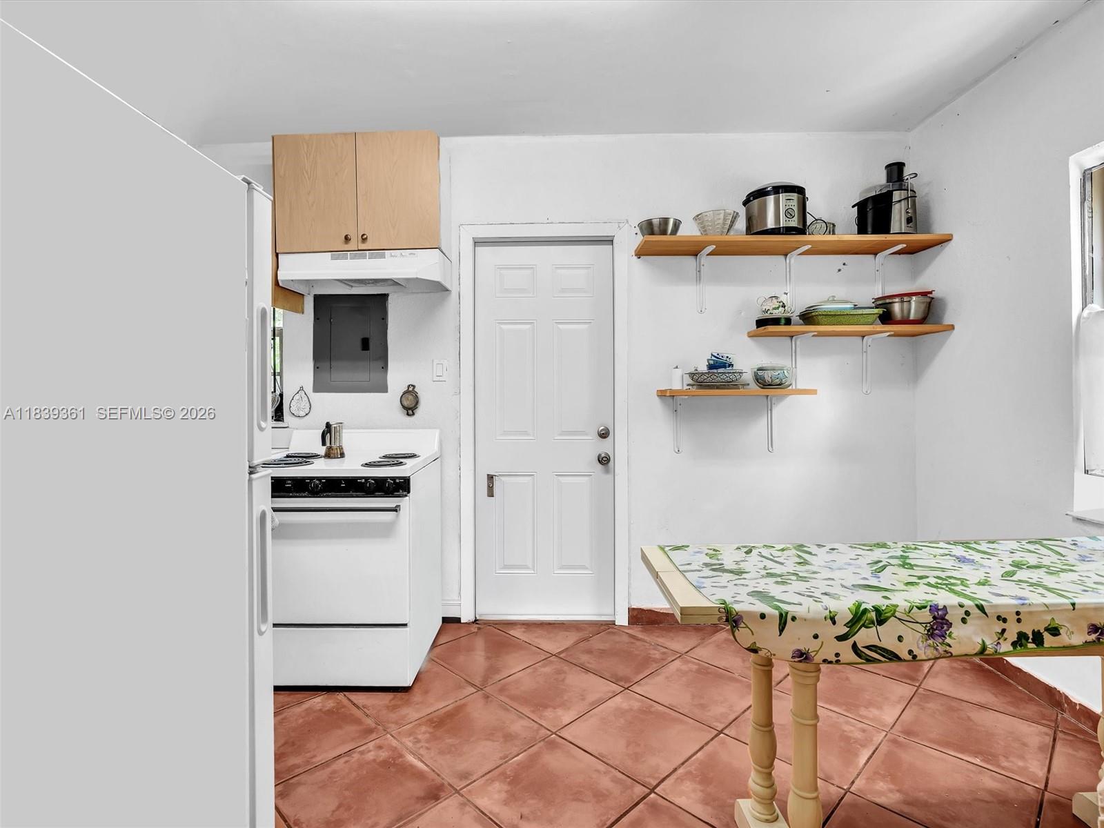 3210 Elizabeth Street Miami, FL 33133 - Photo 48 of 69 a kitchen with kitchen island a stove a sink and a refrigerator