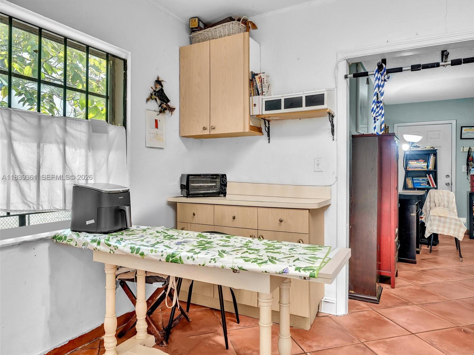 3210 Elizabeth Street Miami, FL 33133 - Photo 56 of 69 a kitchen with a table chairs refrigerator and cabinets