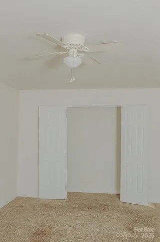 a white toilet sitting next to a white wall