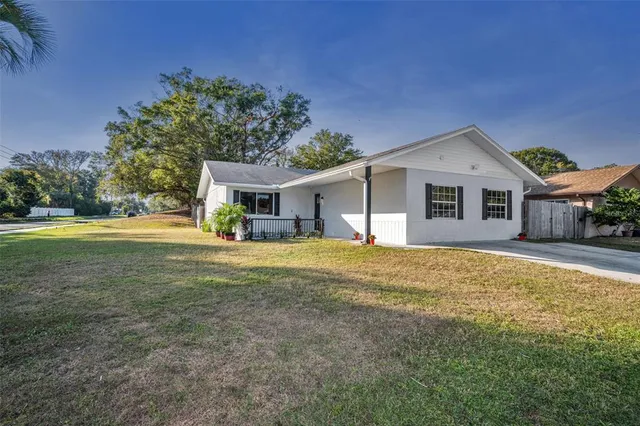 a front view of house with yard and trees in the background
