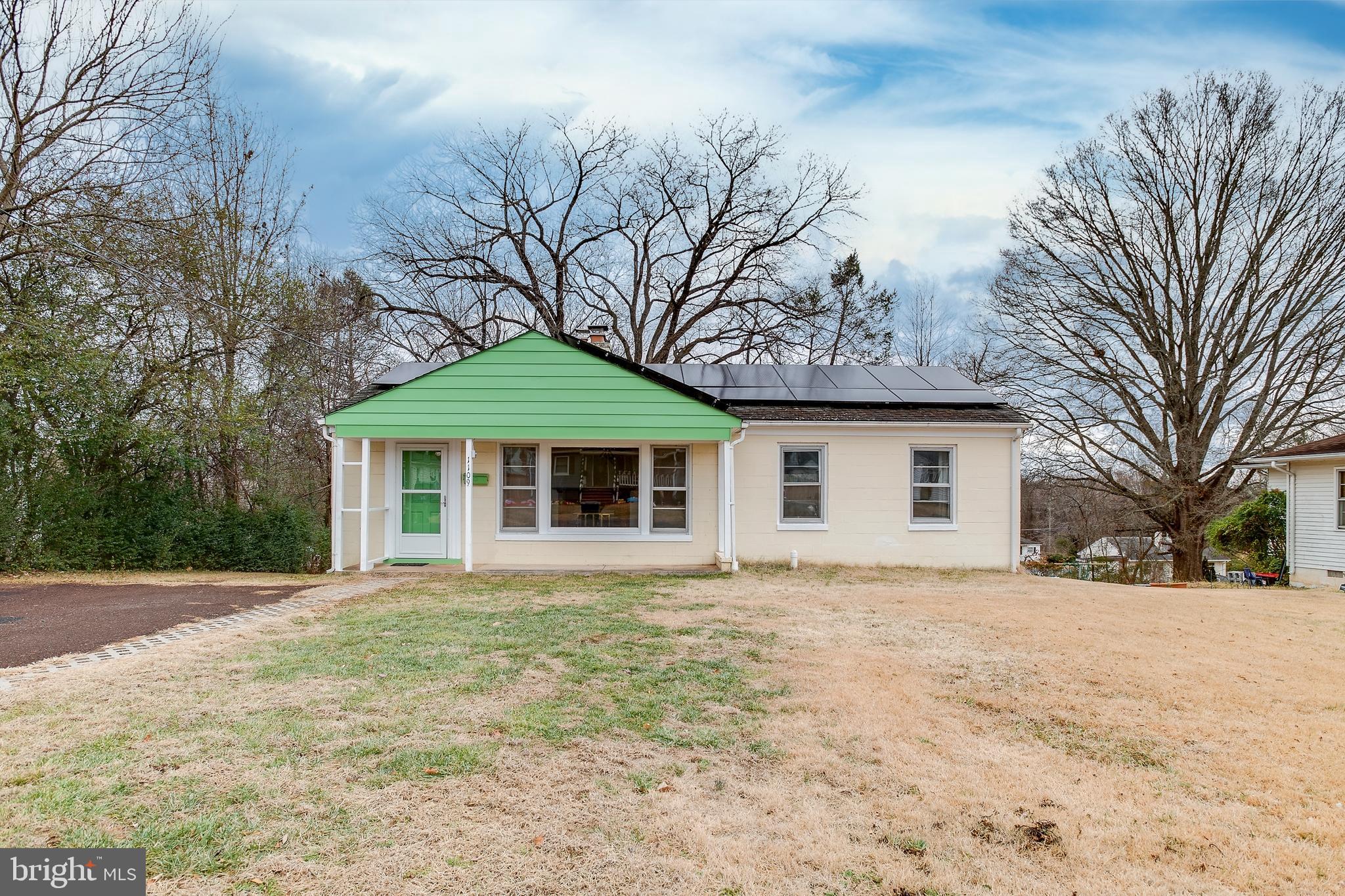a front view of a house with yard and trees
