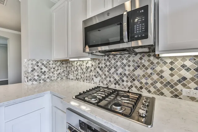 a stove top oven sitting inside of a kitchen