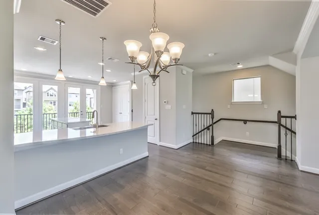 a view of a room with wooden floor and chandelier