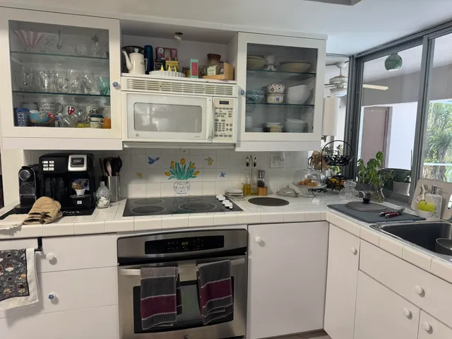 a kitchen with stainless steel appliances a sink stove and cabinets