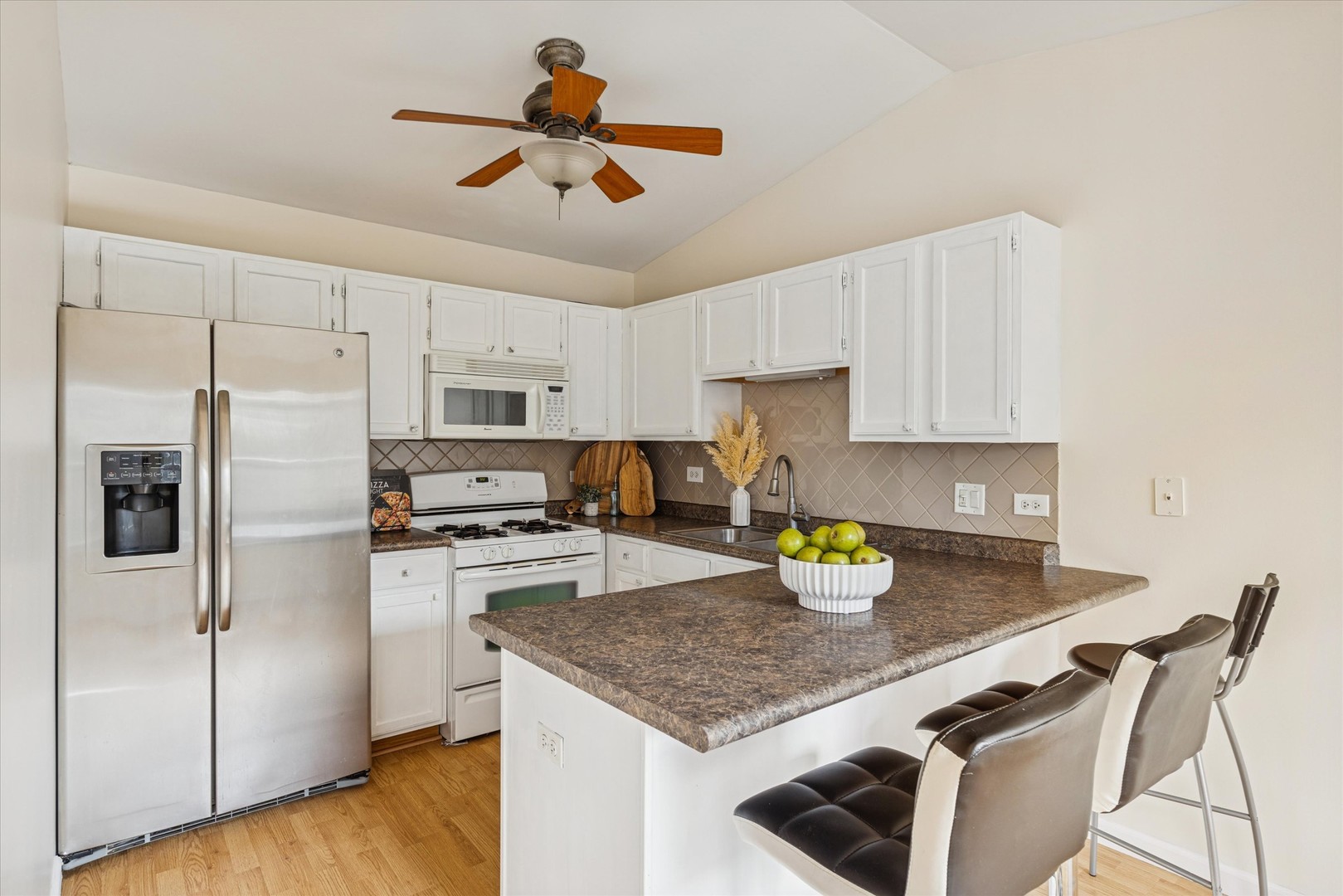 1101 Yorkshire Court, Unit C Elgin, IL 60120 - Photo 6 of 19 a kitchen with a refrigerator a stove a kitchen island and chairs