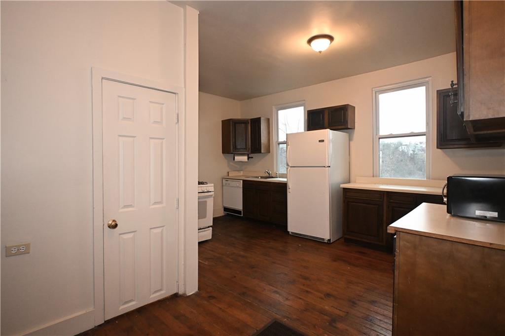 417 Lawn Street Pittsburgh, PA 15213 - Photo 11 of 26 a kitchen with a refrigerator a stove top oven a sink and dishwasher with wooden floor