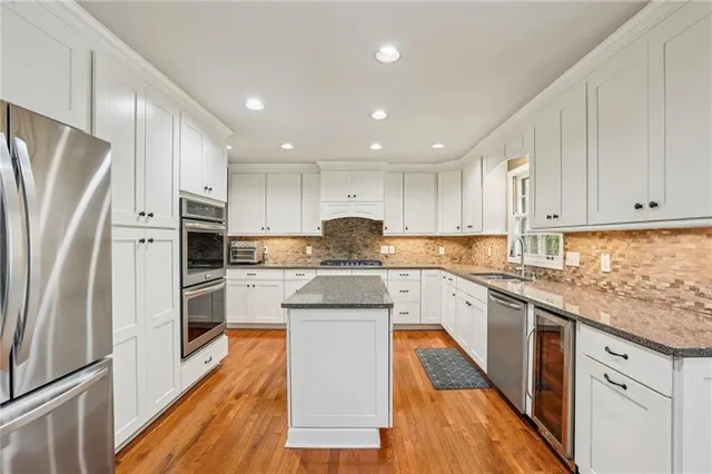 a large kitchen with stainless steel appliances and refrigerator