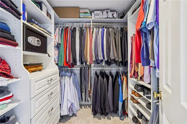 a view of walk in closet with clothes
