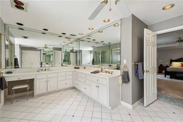 a large white kitchen with a lot of white cabinets appliances and furniture