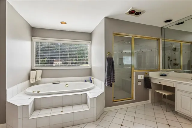 a spacious bathroom with a tub sink shower and mirror