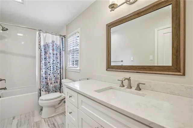 a bathroom with a granite countertop sink toilet a large mirror and shower