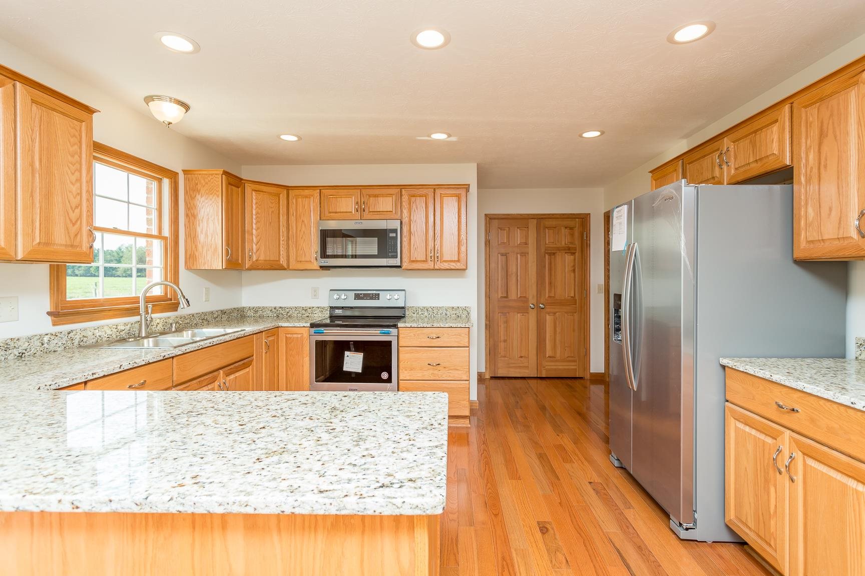 297 Battlefield Road Waynesboro, VA 22980 - Photo 3 of 61 a kitchen with stainless steel appliances granite countertop a refrigerator a sink dishwasher a oven with large countertops and wooden floor