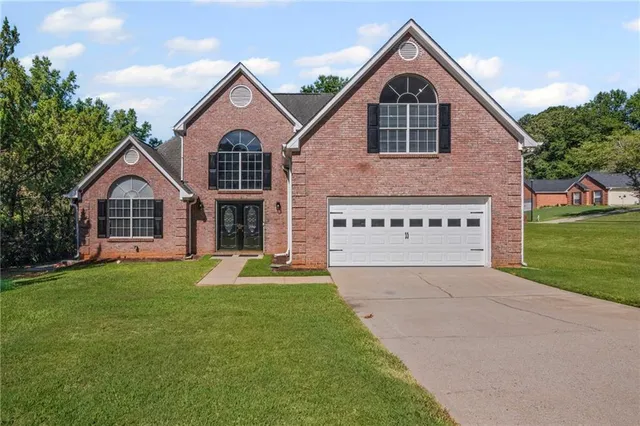 a front view of a house with a yard and garage