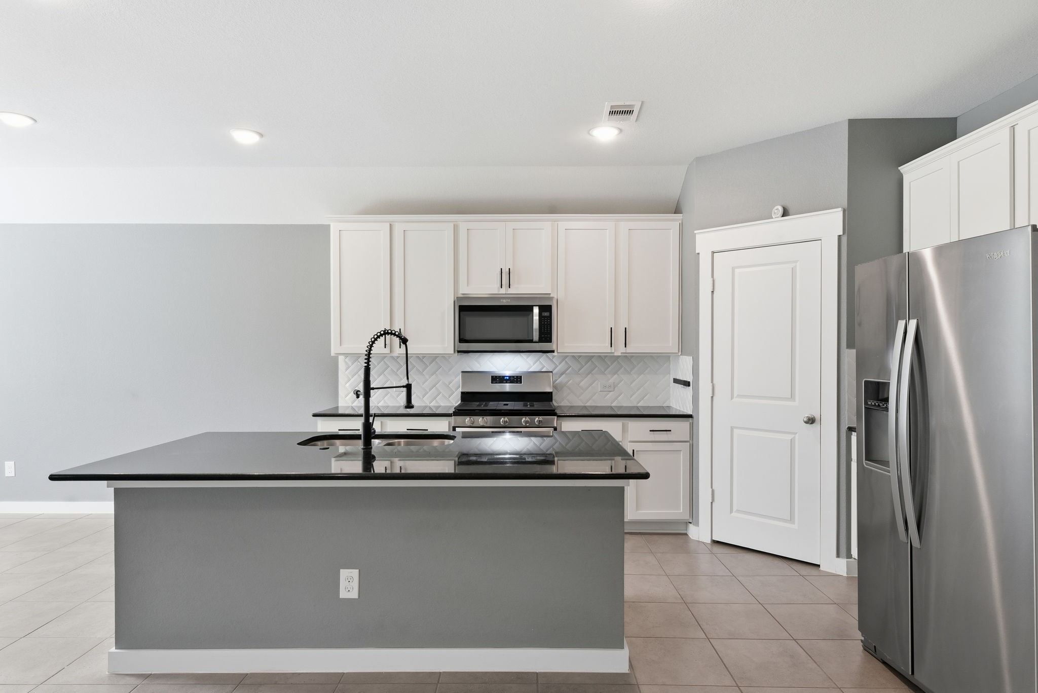 12411 Southern Trail Court Magnolia, TX 77354 - Photo 2 of 38 a kitchen with stainless steel appliances granite countertop a refrigerator a stove top oven and a sink
