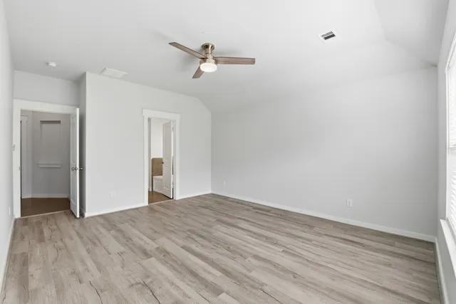 a view of empty room with wooden floor