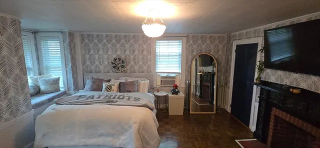 a bedroom with a bed and a large mirror on the dresser