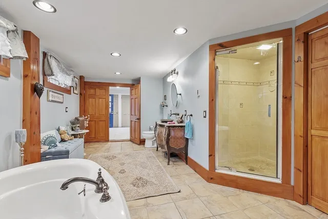 a bathroom with a tub shower and mirror