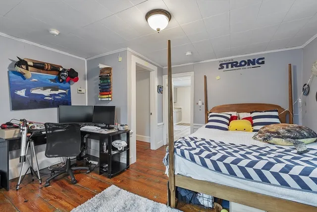 a bedroom with a bed and wooden floor