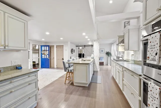 a large white kitchen with stainless steel appliances lots of counter top space