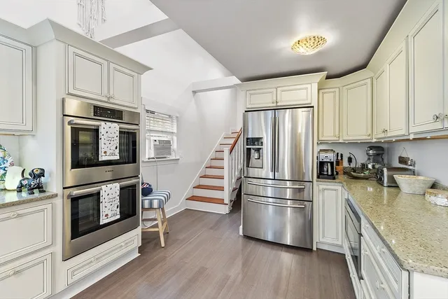 a kitchen with stainless steel appliances and wooden floor