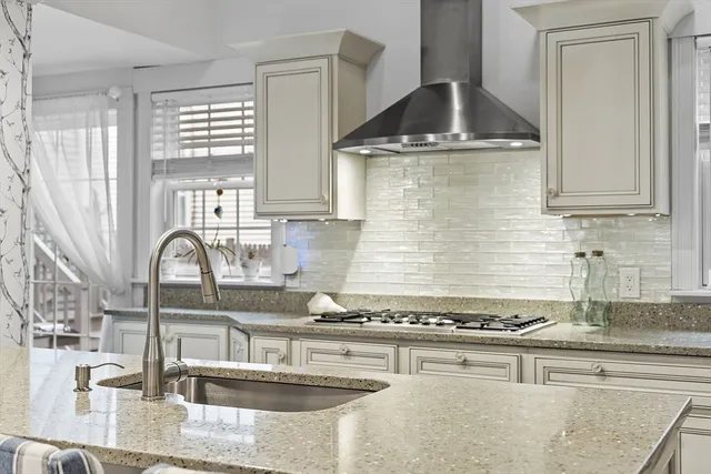 a kitchen with granite countertop a sink a stove and cabinets