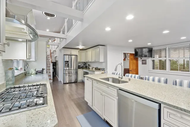 a kitchen with stainless steel appliances kitchen island granite countertop a sink and cabinets