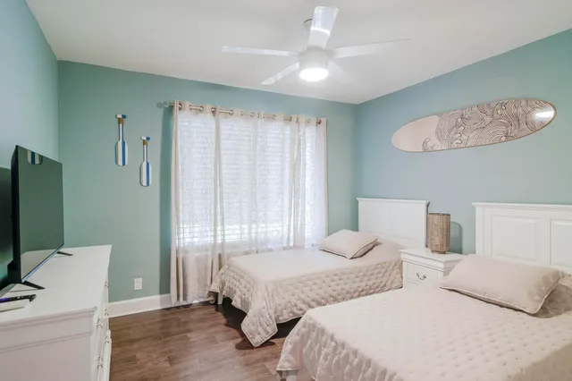 a bedroom with two beds and a chandelier