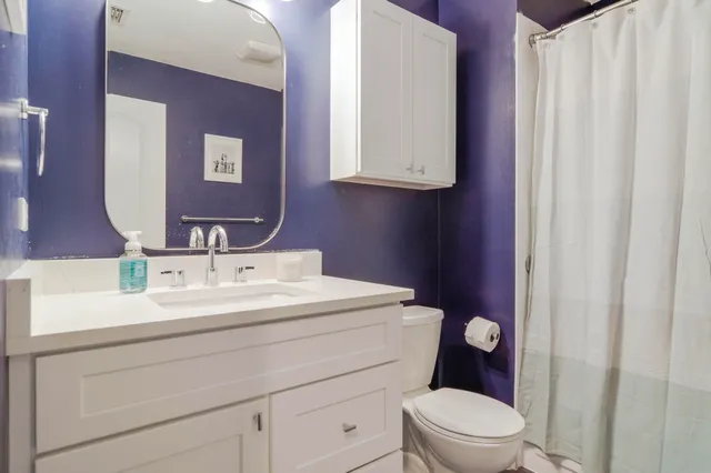 a bathroom with a toilet sink and mirror